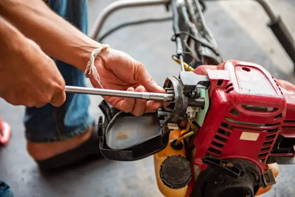 Technician repairing a small engine trimmer